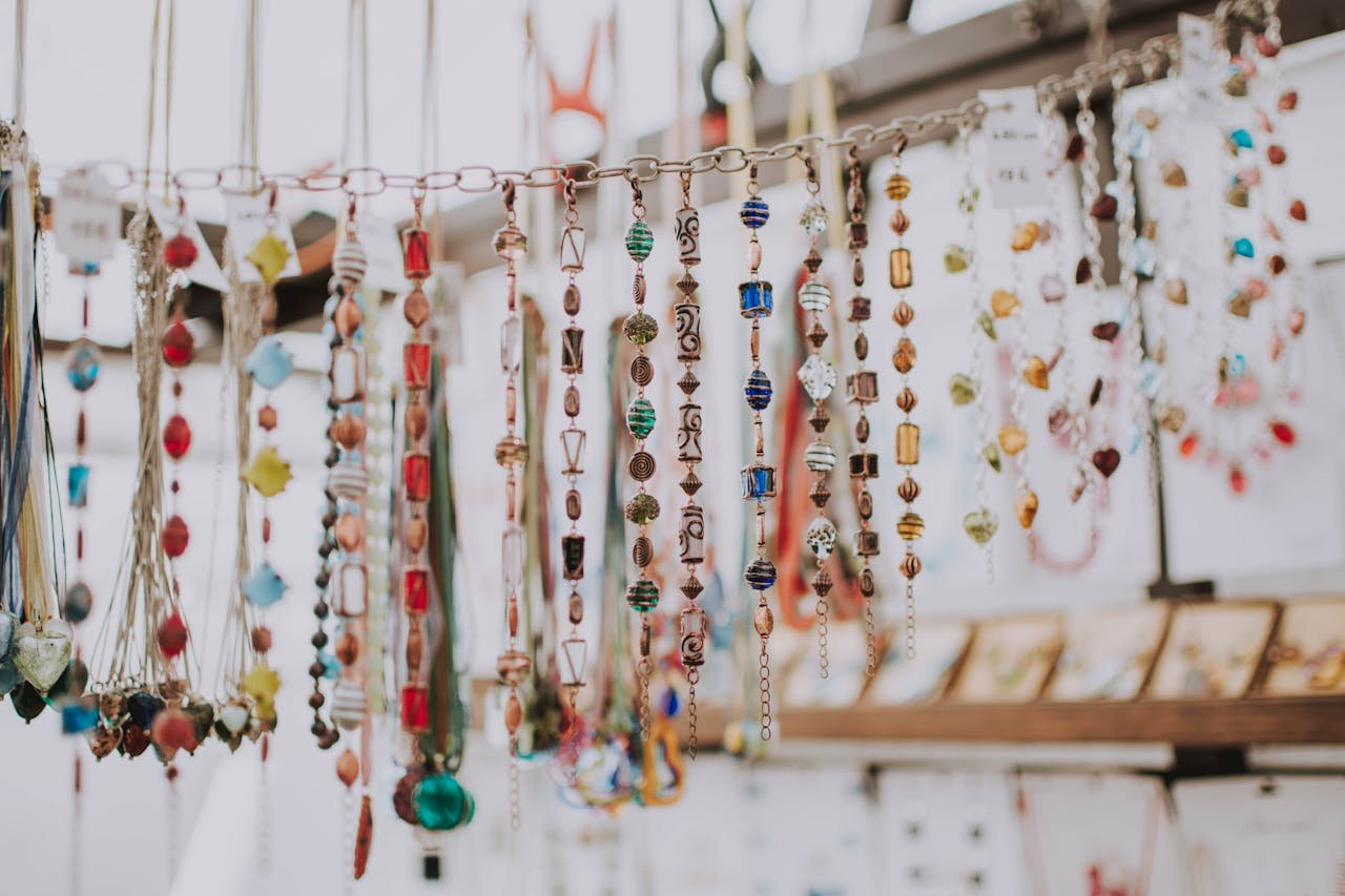 Vibrant collection of handmade beaded jewelry hanging on display, showcasing a variety of colors and designs.